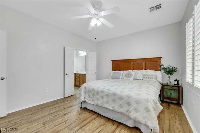 bedroom featuring light wood-type flooring, multiple windows, baseboards, and connected bathroom
