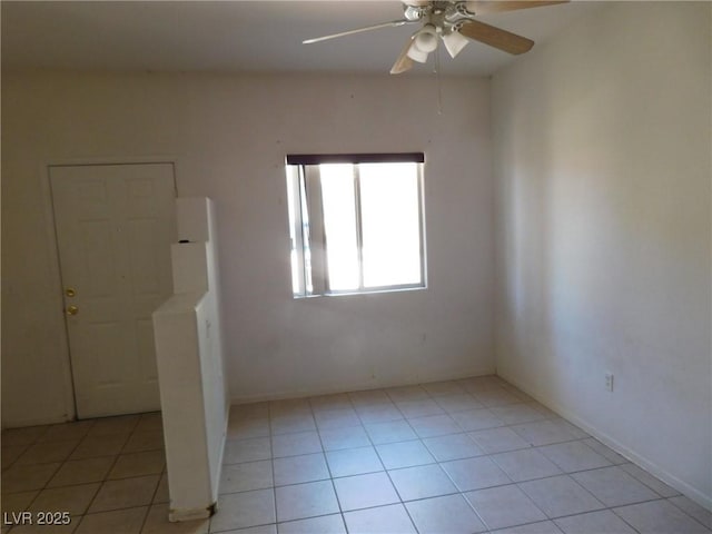 empty room with ceiling fan and light tile patterned floors