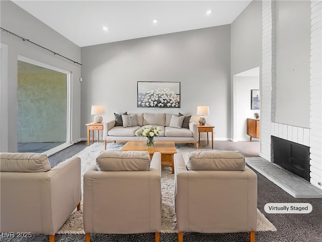 carpeted living room with a fireplace, baseboards, and recessed lighting
