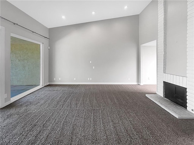 unfurnished living room featuring carpet, a fireplace, baseboards, and recessed lighting