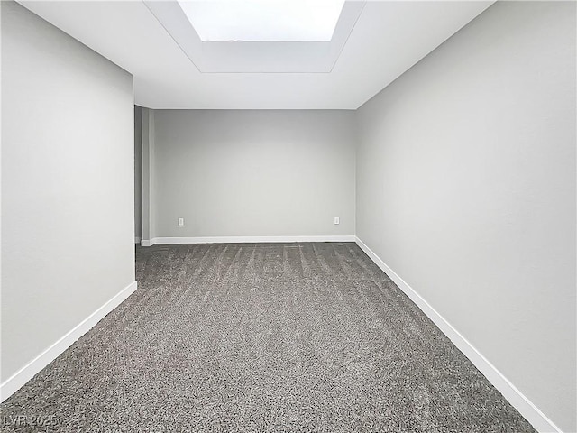 empty room featuring dark carpet and baseboards