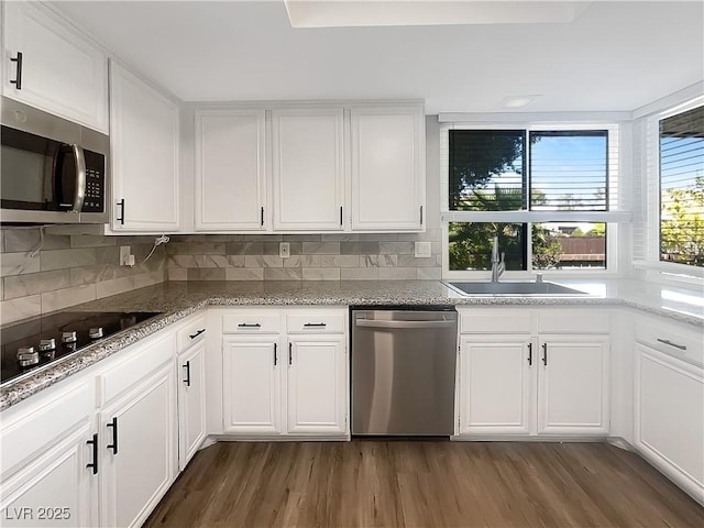 kitchen with stainless steel appliances, a sink, dark wood-type flooring, and white cabinets