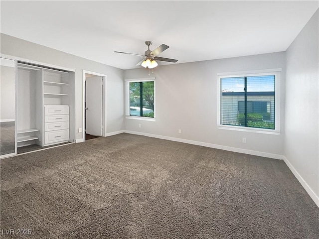 unfurnished bedroom with baseboards, ceiling fan, dark colored carpet, and a closet