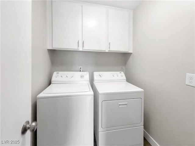 laundry room with washing machine and clothes dryer and cabinet space