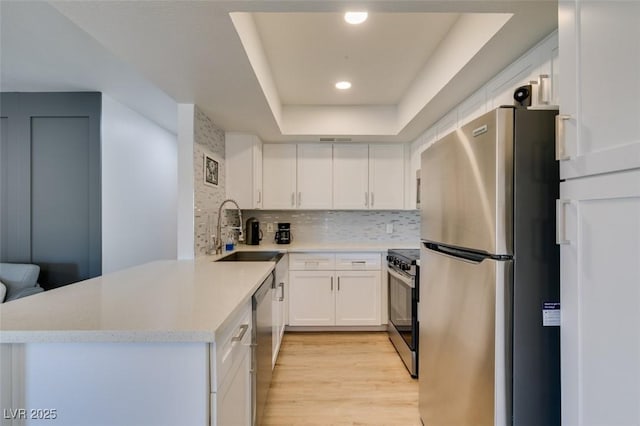 718 Nectarine Ct, Henderson, NV 89014 - kitchen with appliances with stainless steel finishes, a sink, a tray ceiling, light countertops, and white cabinetry