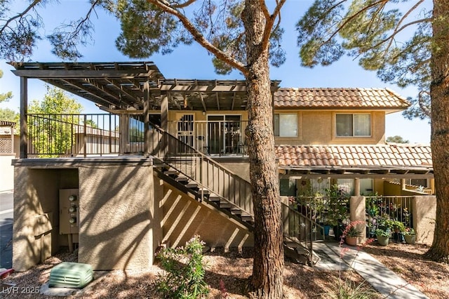 718 Nectarine Ct, Henderson, NV 89014 - rear view of house with a tiled roof, a pergola, stairway, and stucco siding