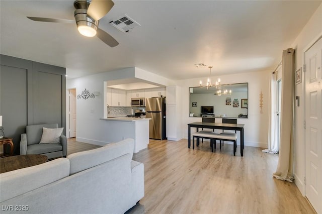 718 Nectarine Ct, Henderson, NV 89014 - living room with a ceiling fan, a chandelier, light wood finished floors, and baseboards
