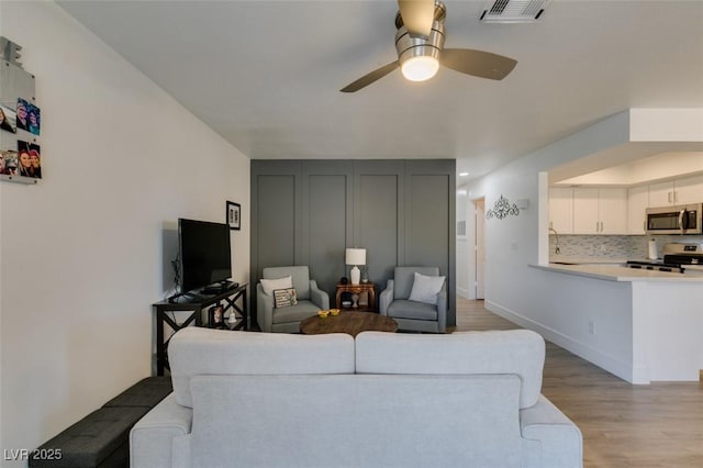718 Nectarine Ct, Henderson, NV 89014 - living room with light wood-type flooring, ceiling fan, and baseboards