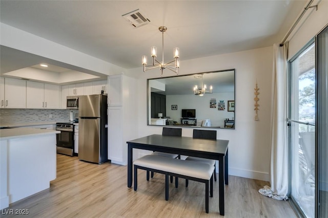 718 Nectarine Ct, Henderson, NV 89014 - dining area with a chandelier, light wood-style floors, baseboards, and a tray ceiling