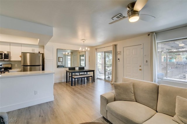 718 Nectarine Ct, Henderson, NV 89014 - living room featuring a chandelier, light wood-type flooring, a ceiling fan, and baseboards