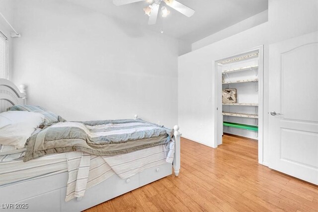 8985 S Durango Dr Unit 1110, Las Vegas, NV 89113 - bedroom featuring a spacious closet, wood finished floors, a ceiling fan, and a closet