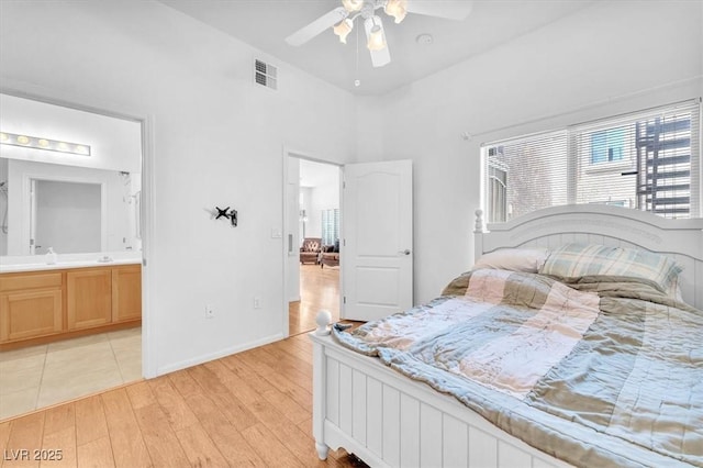 8985 S Durango Dr Unit 1110, Las Vegas, NV 89113 - bedroom featuring light wood-style flooring, multiple windows, connected bathroom, a ceiling fan, and a towering ceiling