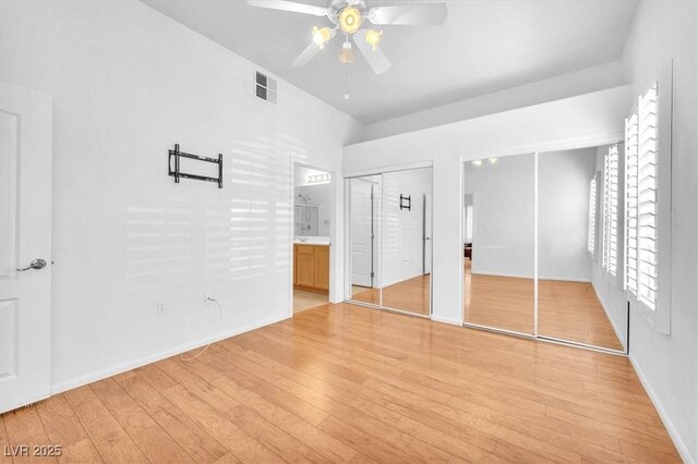 8985 S Durango Dr Unit 1110, Las Vegas, NV 89113 - unfurnished bedroom featuring two closets, light wood finished floors, baseboards, ensuite bathroom, and ceiling fan