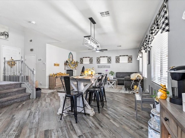 dining area with wood finished floors, stairs, ceiling fan, and baseboards