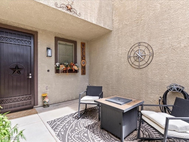 property entrance featuring stucco siding and a patio