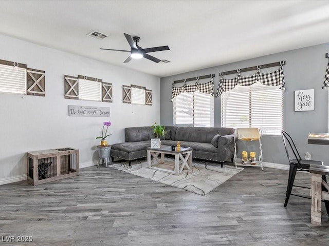 living area with wood finished floors, ceiling fan, and baseboards