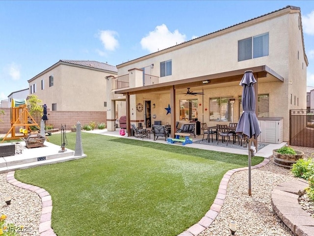 back of property with an outdoor fire pit, stucco siding, a patio, and a ceiling fan