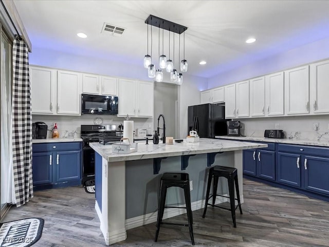 1604 Patrick Thomas Ct, North Las Vegas, NV 89086 - kitchen featuring black appliances, blue cabinetry, dark wood-style floors, a kitchen bar, and a sink