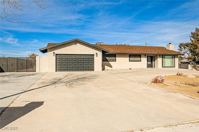 9340 W Washburn Rd, Las Vegas, NV 89149 - single story home with stucco siding, driveway, a garage, fence, and a chimney