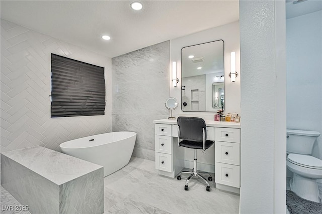 9340 W Washburn Rd, Las Vegas, NV 89149 - full bathroom with toilet, a freestanding tub, marble finish floors, vanity, and recessed lighting