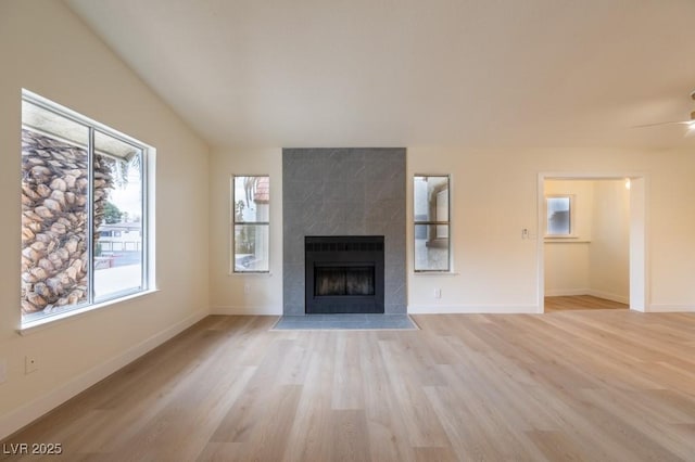 5040 Spencer St Unit D, Las Vegas, NV 89119 - unfurnished living room featuring light wood finished floors, a tile fireplace, baseboards, and ceiling fan
