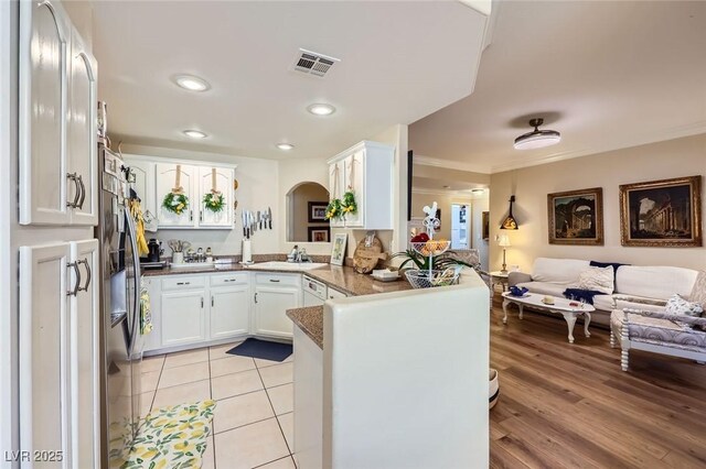 2050 W Warm Springs Rd Unit 3211, Henderson, NV 89014 - kitchen with open floor plan, a peninsula, white cabinetry, crown molding, and arched walkways