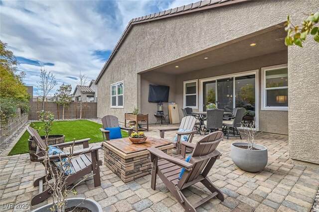 view of patio with a fenced backyard, an outdoor fire pit, and outdoor dining space