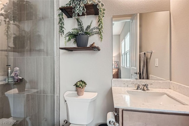 bathroom with toilet, an enclosed shower, and vanity