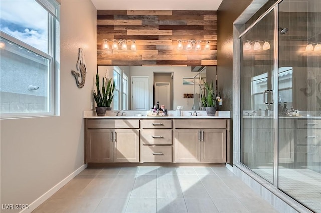 full bathroom featuring a stall shower, tile patterned floors, double vanity, and baseboards