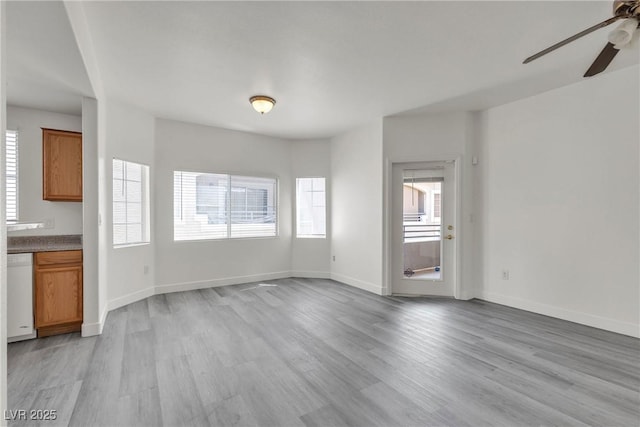 unfurnished living room featuring ceiling fan, plenty of natural light, and light wood finished floors