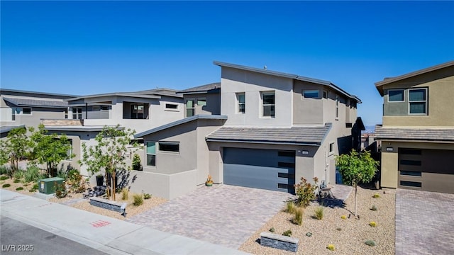 436 Crown Mesa Ave, Las Vegas, NV 89138 - contemporary home featuring stucco siding, a garage, decorative driveway, and cooling unit