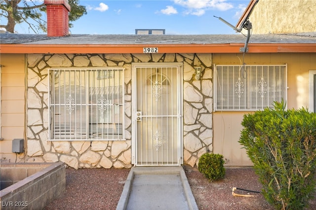 3982 Voxna St, Las Vegas, NV 89119 - view of exterior entry featuring stone siding and a chimney