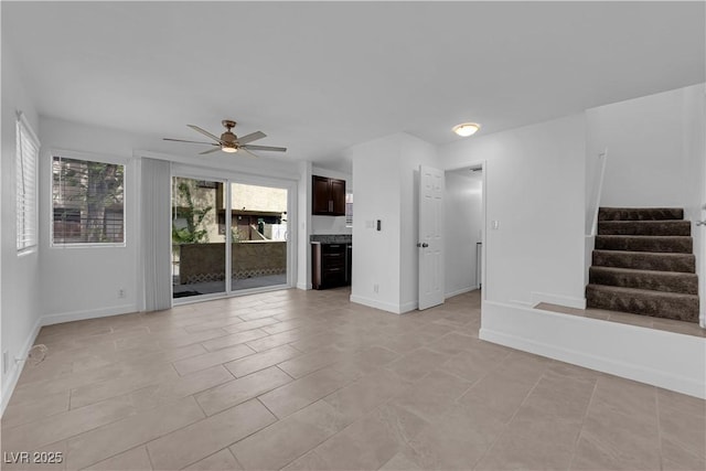 5029 Spencer St Unit D, Las Vegas, NV 89119 - unfurnished living room featuring ceiling fan, stairway, baseboards, and light tile patterned floors