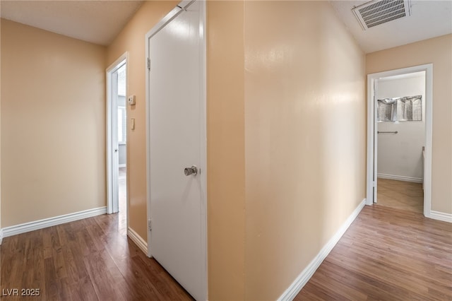 hallway featuring wood finished floors and baseboards