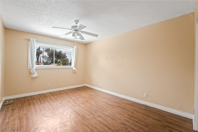 spare room with a ceiling fan, wood finished floors, baseboards, and a textured ceiling
