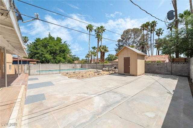 view of patio featuring a storage shed, a fenced backyard, and an outdoor structure