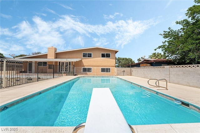 view of pool featuring fence, a patio, and a diving board