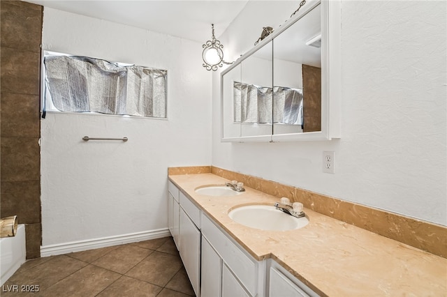 bathroom featuring tile patterned flooring, double vanity, and baseboards