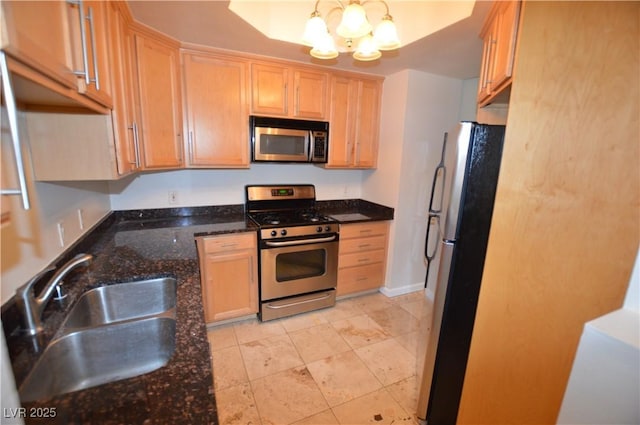 270 E Flamingo Rd Unit 136, Las Vegas, NV 89169 - kitchen featuring stainless steel appliances, a sink, a chandelier, dark stone countertops, and light brown cabinetry