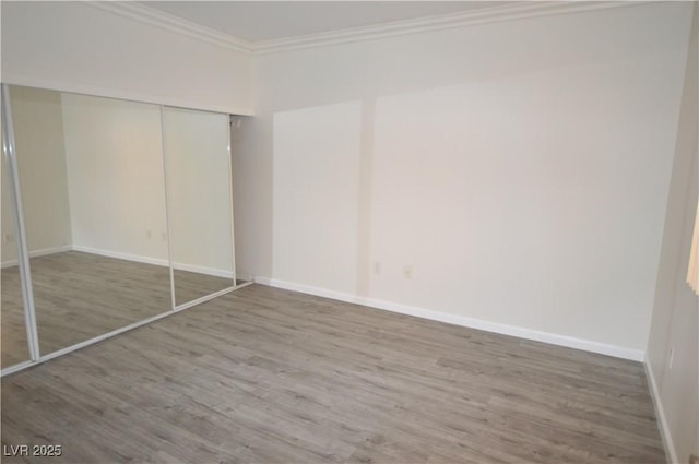 270 E Flamingo Rd Unit 136, Las Vegas, NV 89169 - unfurnished bedroom featuring wood finished floors, ornamental molding, baseboards, and a closet