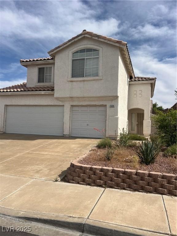 128 Appian Way, Henderson, NV 89002 - view of front of property with a tile roof, a garage, stucco siding, and concrete driveway