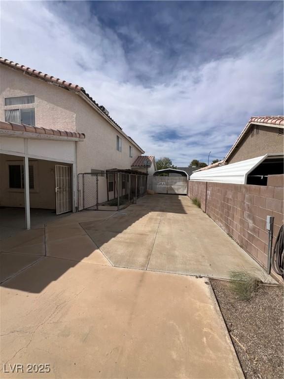 128 Appian Way, Henderson, NV 89002 - view of property exterior with a fenced backyard, a tiled roof, stucco siding, and a patio area