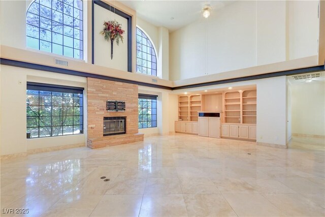 1931 Pago Ct, Las Vegas, NV 89117 - unfurnished living room featuring a high ceiling, marble tiled floors, and a glass covered fireplace