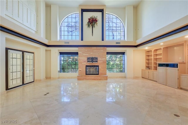 1931 Pago Ct, Las Vegas, NV 89117 - unfurnished living room featuring a high ceiling, a large fireplace, and baseboards