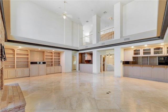1931 Pago Ct, Las Vegas, NV 89117 - unfurnished living room with a towering ceiling, light marble finish flooring, ceiling fan, and built in shelves