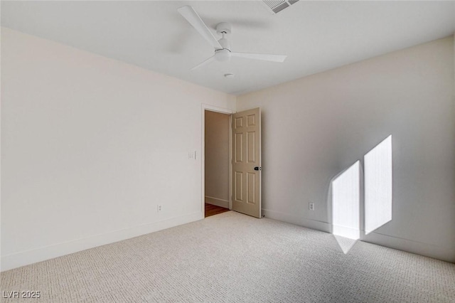 carpeted empty room with a ceiling fan and baseboards