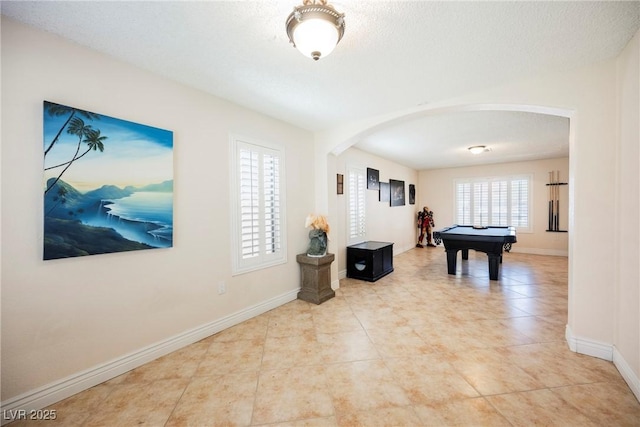 playroom with arched walkways, pool table, baseboards, and tile patterned flooring