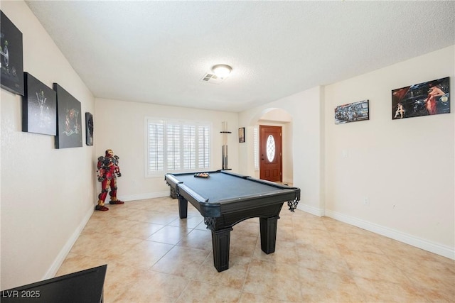 rec room with arched walkways, pool table, baseboards, a textured ceiling, and light tile patterned floors