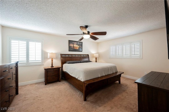 bedroom with light carpet, baseboards, ceiling fan, and a textured ceiling