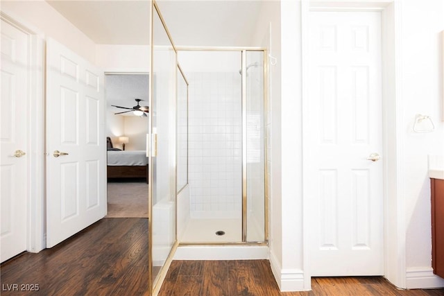 bathroom with wood finished floors, a shower stall, and ensuite bath